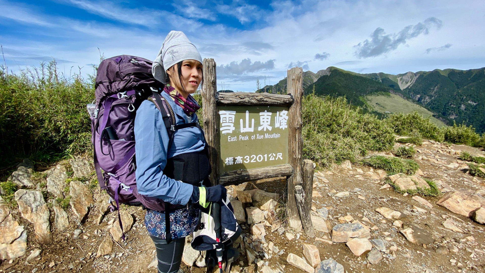 第一日重裝登頂雪山東峰時勉力露出的微笑。大背包裡面有著帳篷，讓我笑封自己為模特兼協作。