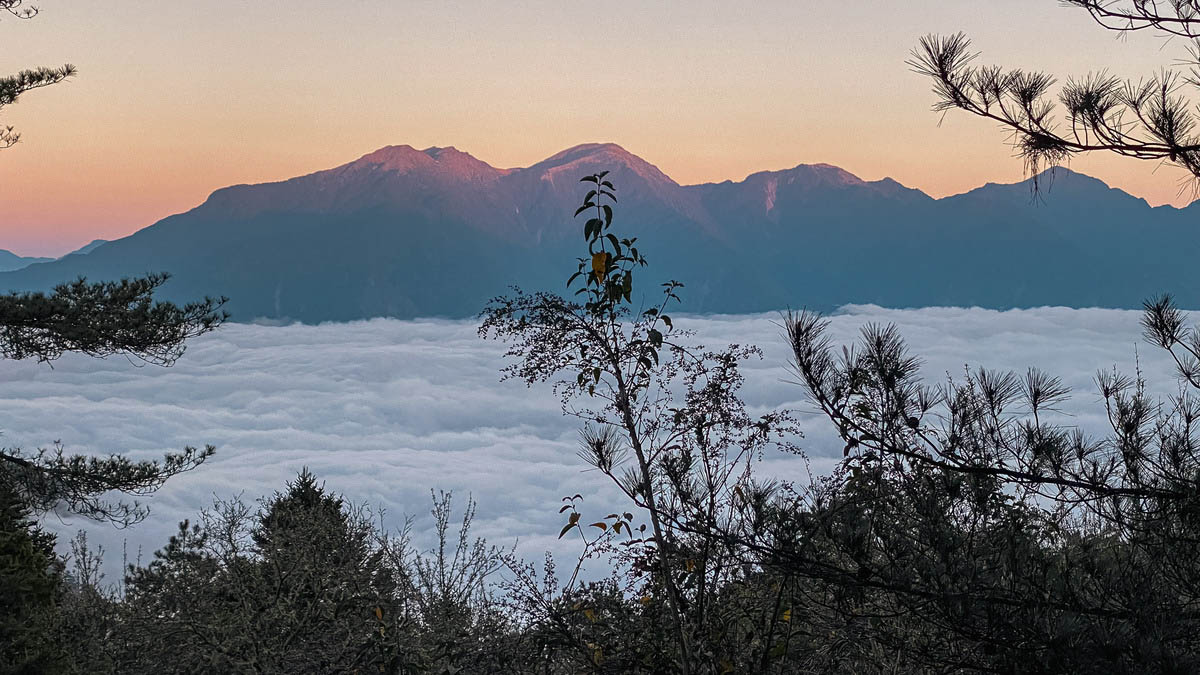 巒安堂遺跡旁和人群一起對望雲海後的大山群,山頂被夕陽染成美麗的紫色。祂們是百岳中公認最難的「南三段」。