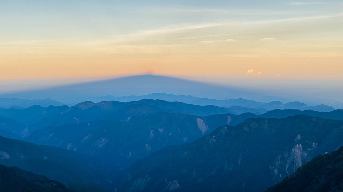 稍晚獨自從排雲山莊爬往玉山主峰的江,拍下了日出時分玉山在半空中的「影子」。