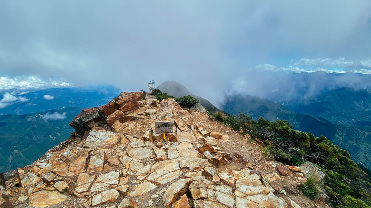 玉山北峰三角點,正前方看去那座雲霧若隱若現的山峰,即玉山北北峰。