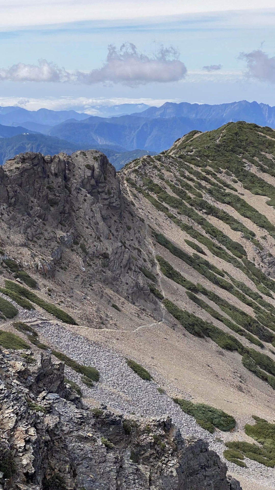 江在玉山南峰頂拍下的登頂路,登山者就是一路沿著畫面中窄窄的白色線條走過來。原來我在黑暗中是走這麼險峻的路欸。
